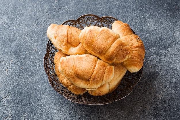 Croissants con relleno de chocolate sobre un fondo gris de la placa.