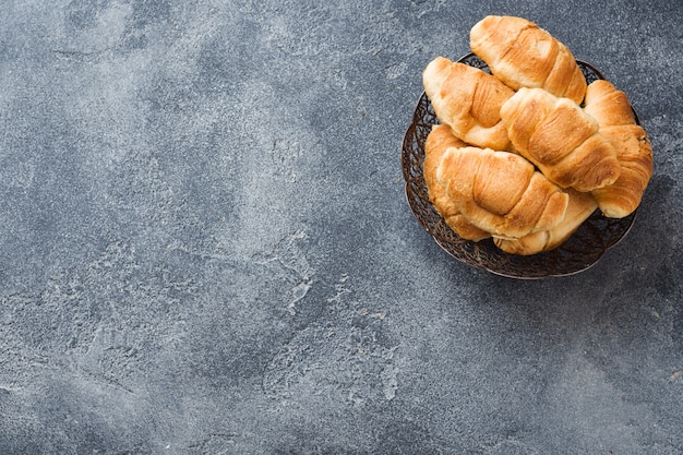 Croissants con relleno de chocolate sobre un fondo gris de la placa.