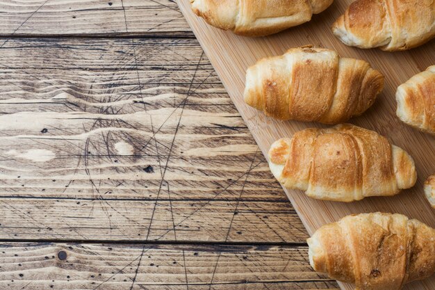 Croissants con relleno de chocolate sobre fondo de madera. Copia espacio