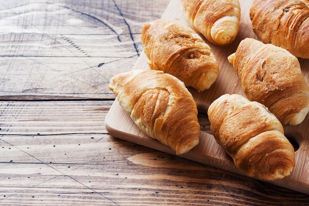 Croissants con relleno de chocolate sobre fondo de madera. Copia espacio