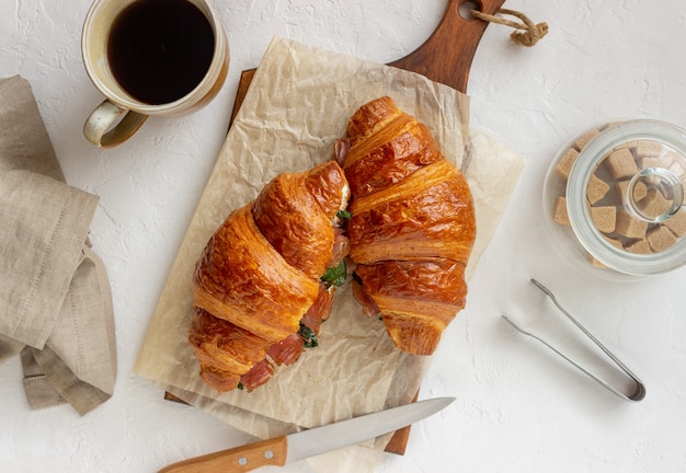 Croissants Sandwiches mit Schinken, Basilikum und Weißkäse. Französische Küche. Frühstück.