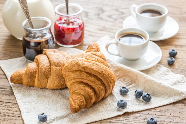 Croissants con tazas de café y leche.