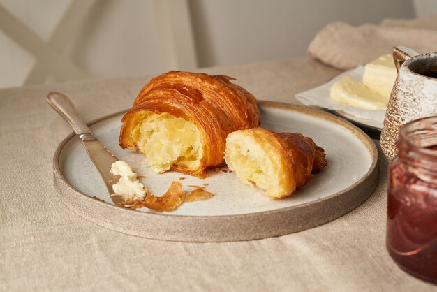 Croissants um deliciosos no prato e bebida quente na caneca. café da manhã francês