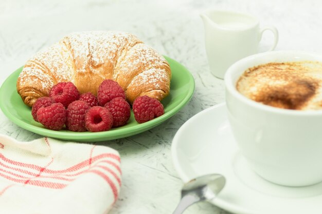 Croissants und frische Himbeeren Frische und leckere Croissants