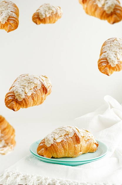 croissants voadores com flocos de amêndoa e açúcar em pó