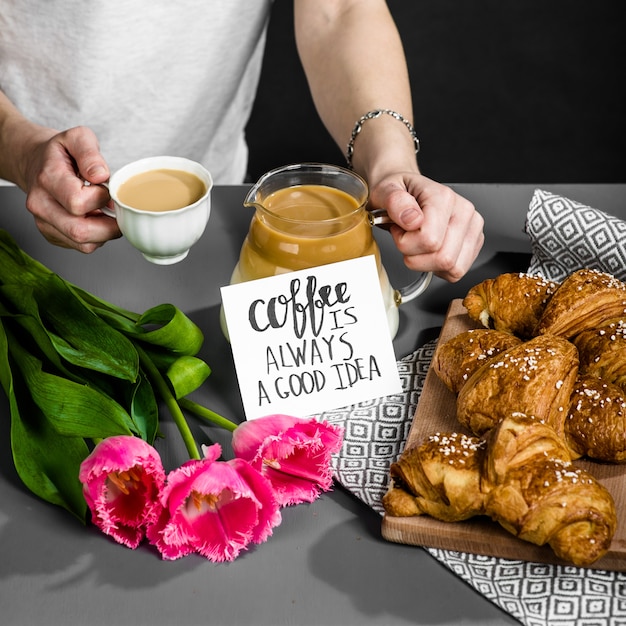 Croissants xícara de café e um buquê de tulipas