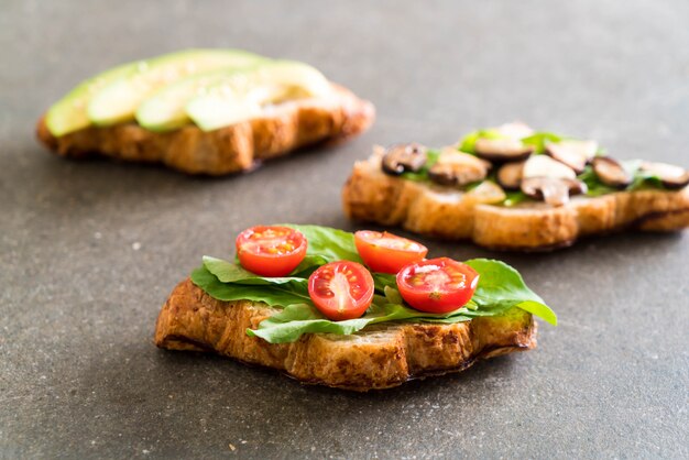 Croissantsandwich mit Avocado, Tomaten und Pilzen