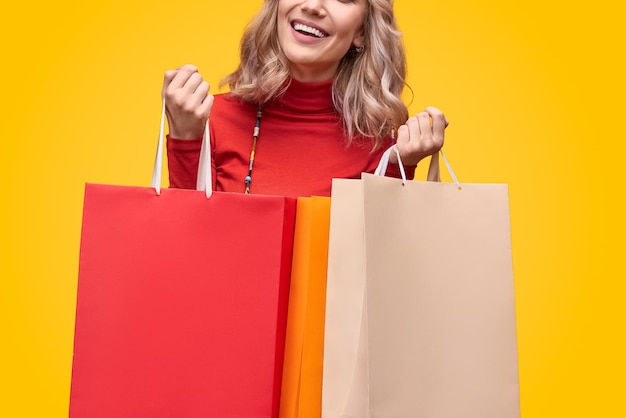 Crop fröhliche Frau mit Papiertüten