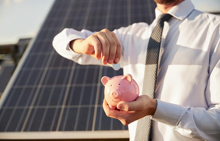 Crop Geschäftsmann spart Geld in der Nähe von Solarpanel