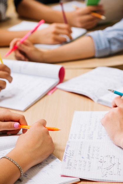 Foto crop manos de los estudiantes en el escritorio