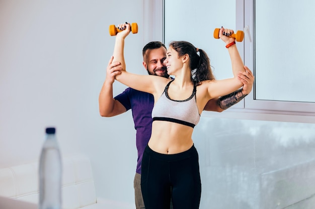 Crop-Top-Sport-BH an Frau während Fitness zu Hause mit Trainer