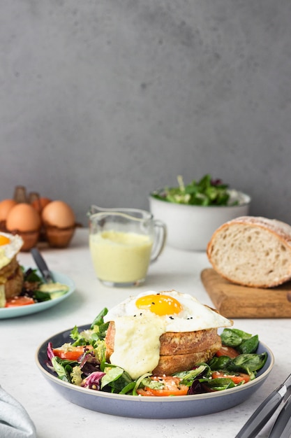 Croque Madame con jamón, emmental derretido, huevo frito y bechamel.