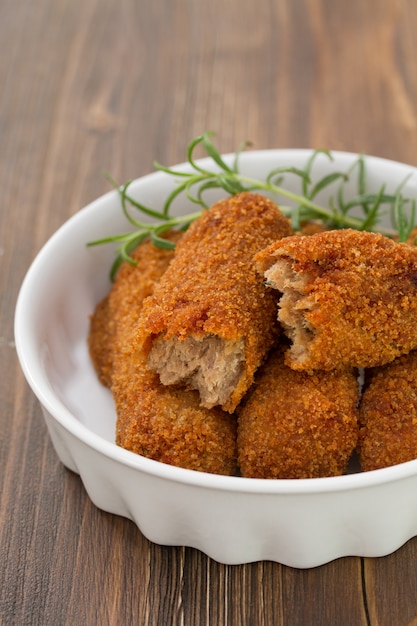 Croquetas de carne en plato blanco sobre madera marrón