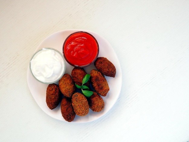 Croquetas de espinacas fritas y queso con salsas