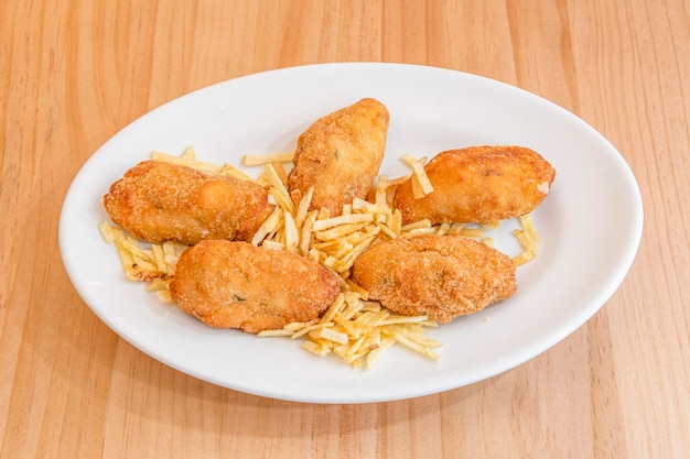 Croquetas fritas caseras con patatas paja listas para servir de tapas