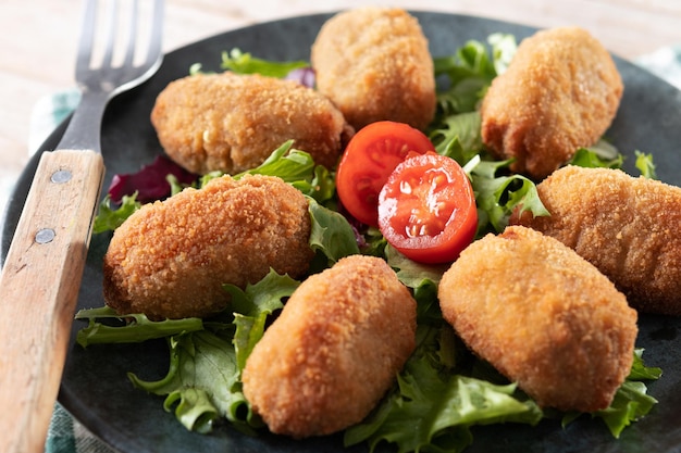 Croquetas fritas tradicionales españolas sobre mesa de madera