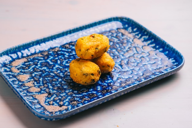 Croquetas o croquetas tradicionales españolas en una placa azul. Comida de tapas.