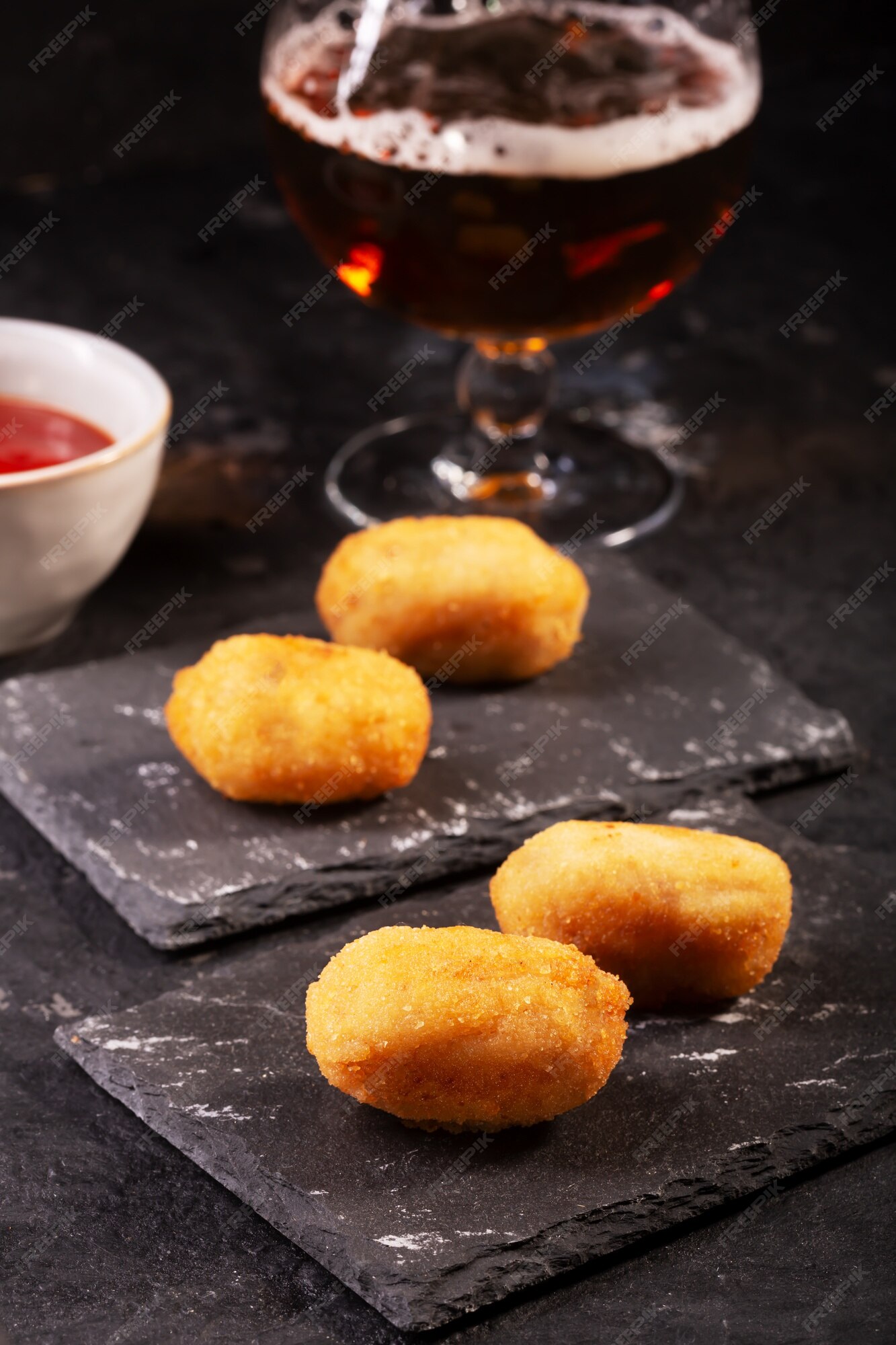 Croquete caseiro tradicional espanhol no garfo com fundo escuro