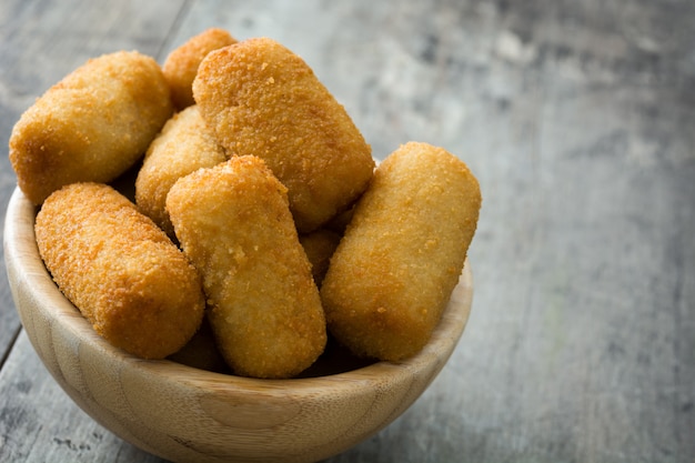 Croquetes espanhóis fritos tradicionais (croquetes) na tigela sobre fundo de madeira