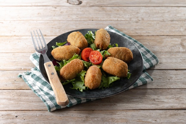 Croquetes fritos espanhóis tradicionais na mesa de madeira