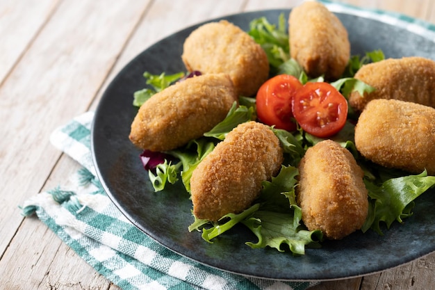 Croquetes fritos espanhóis tradicionais na mesa de madeira