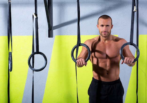 Crossfit dip ring hombre relajado después de hacer ejercicio en el gimnasio