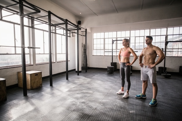 Crossfit-Paare, die mit den Händen auf Hüften aufwerfen