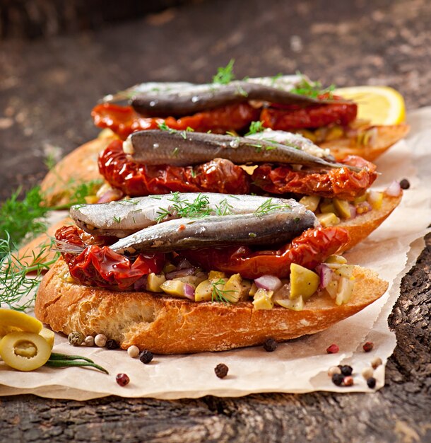 Crostini com anchovas, azeitonas e tomates secos ao sol