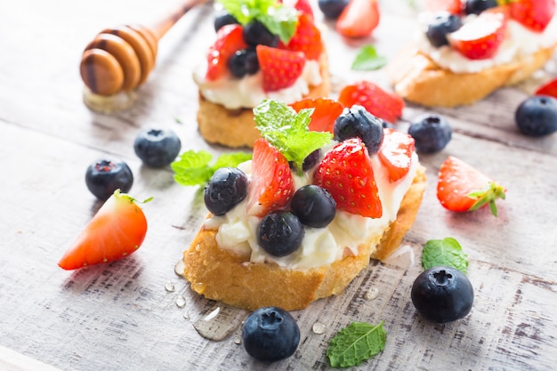 Crostini com baguete grelhado, cream cheese e frutas vermelhas