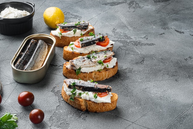 Crostini com peixe e ricota, no fundo da mesa de pedra cinza, com espaço de cópia para o texto