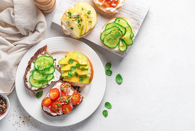 Foto crostini con feta verduras frutas y hierbas frescas sobre un fondo gris vista superior espacio de copia