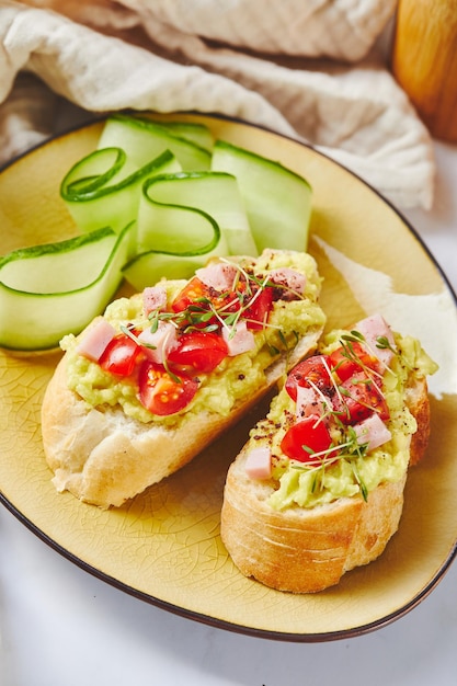 Crostini ou bruschetta com presunto de abacate amolecido e torradas de tomate com purê de abacate