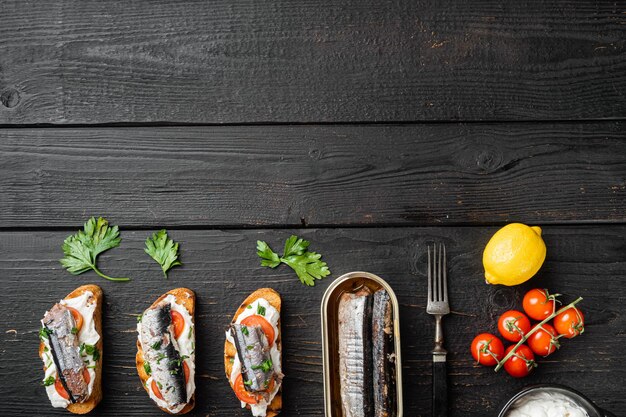 Crostini con pescado y ricotta, sobre fondo de mesa de madera negra, vista superior plana, con espacio para copiar texto