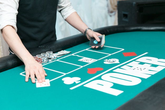 Croupier am Pokertisch im Casino. Chips und Karten auf dem Tisch.