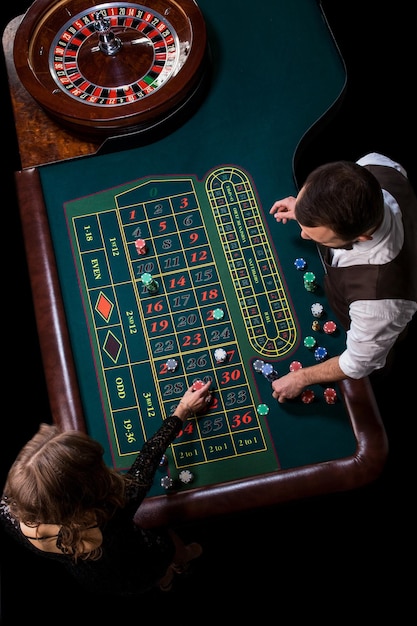 Croupier y jugadora en una mesa en un casino. Imagen de una rueda de ruleta de casino clásica. Juego. Casino. Ruleta. Póker. Vista superior de una mesa de ruleta verde