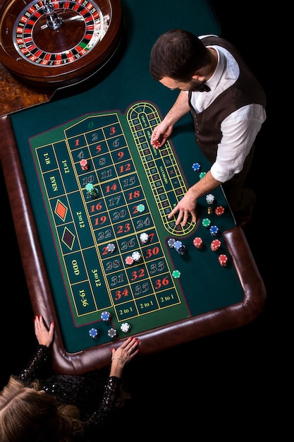 Croupier y jugadora en una mesa en un casino. Imagen de una rueda de ruleta de casino clásica. Juego. Casino. Ruleta. Póker. Vista superior de una mesa de ruleta verde