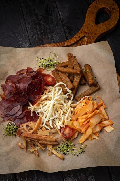 croutons, queijos, carne defumada em uma mesa de madeira