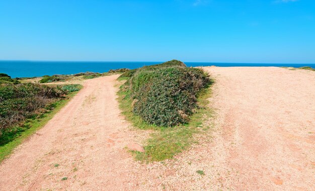 Cruce de caminos en un país rojo por la costa de Porticciolo Cerdeña