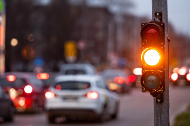 Cruce de la ciudad con un semáforo en fondo borroso con coches en las calles de la noche luz naranja