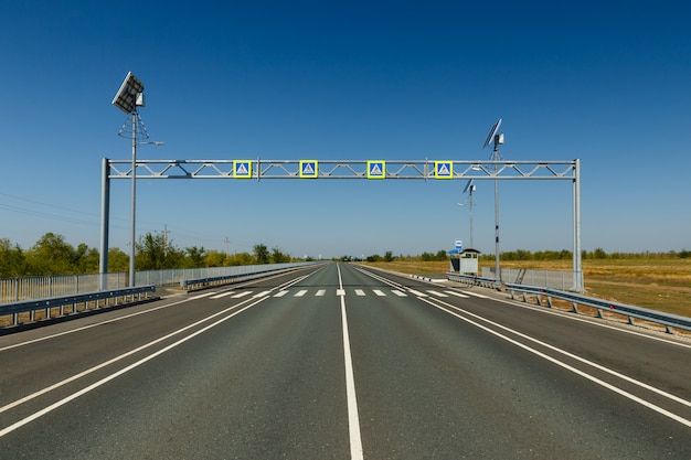 Cruce peatonal, señal de tráfico azul con un símbolo peatonal sobre una carretera de asfalto