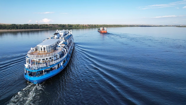 Cruceros en el transatlántico a lo largo del barco de pasajeros del Volga con turistas a bordo que vuelan para adelantar a un petrolero en Volgogrado, Rusia