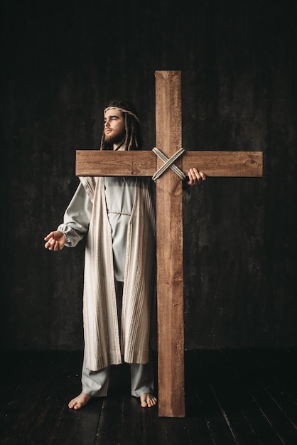 Crucificação de jesus cristo, símbolo da religião cristã. homem com cruz no preto