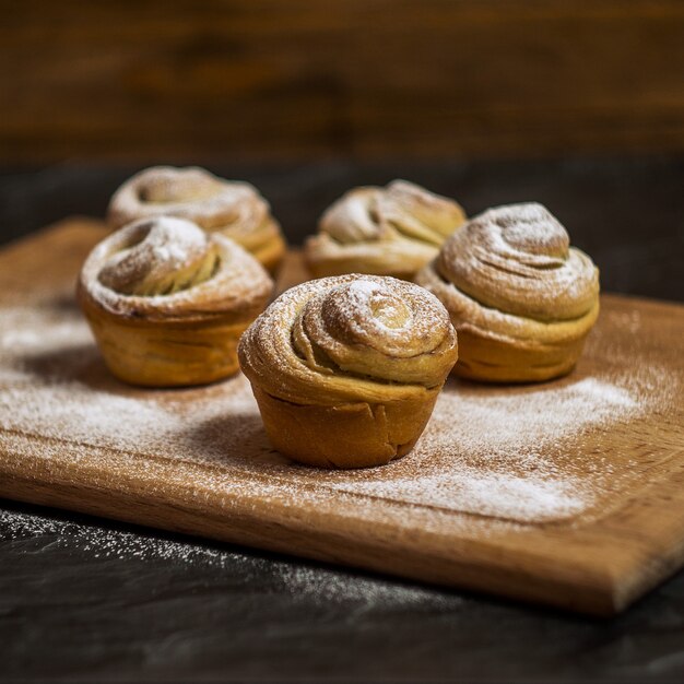 Cruffins de pastelaria caseira, muffin com açúcar em pó, na mesa de madeira e escuro, seletivo foco, quadrado