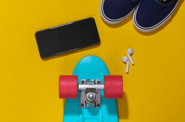 Cruiser Board, Sneaker, Smartphone und kabellose Kopfhörer