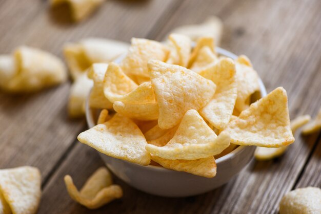 crujientes galletas de gambas chips en un tazón blanco y fondo de mesa de madera