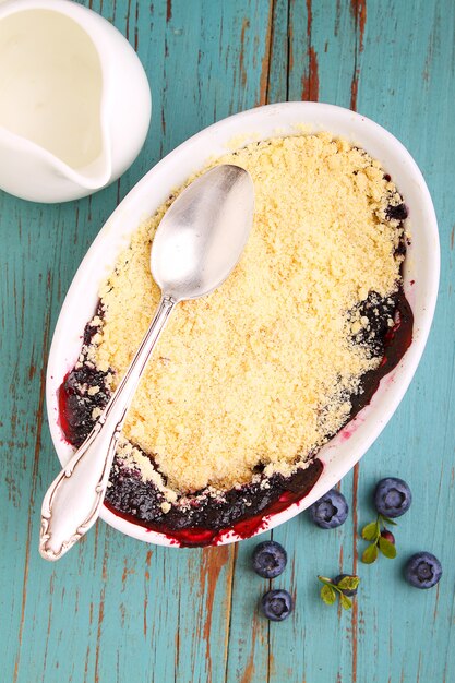 Crumble con arándanos, arándanos en plato blanco.