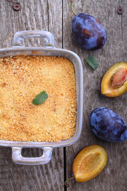 Crumble com ameixas e canela em um fundo preto