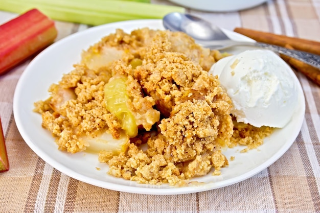 Crumble com ruibarbo e sorvete em tigela na toalha de linho