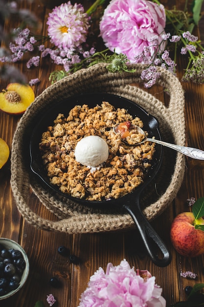 Crumble crujiente de arándanos y duraznos con helado