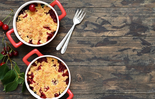 Crumble mit Kirschen und Nüssen auf einem hölzernen Hintergrund